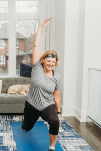 woman in grey performs warrior pose