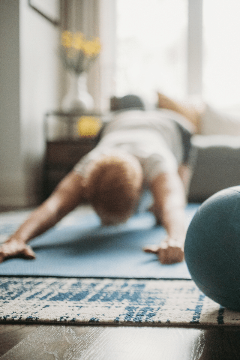 woman in grey performs child's pose