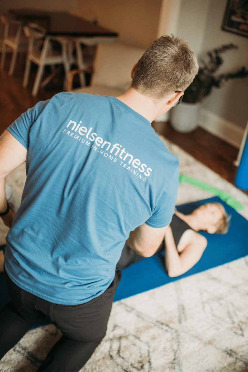 a trainer assists a client with a mat exercise