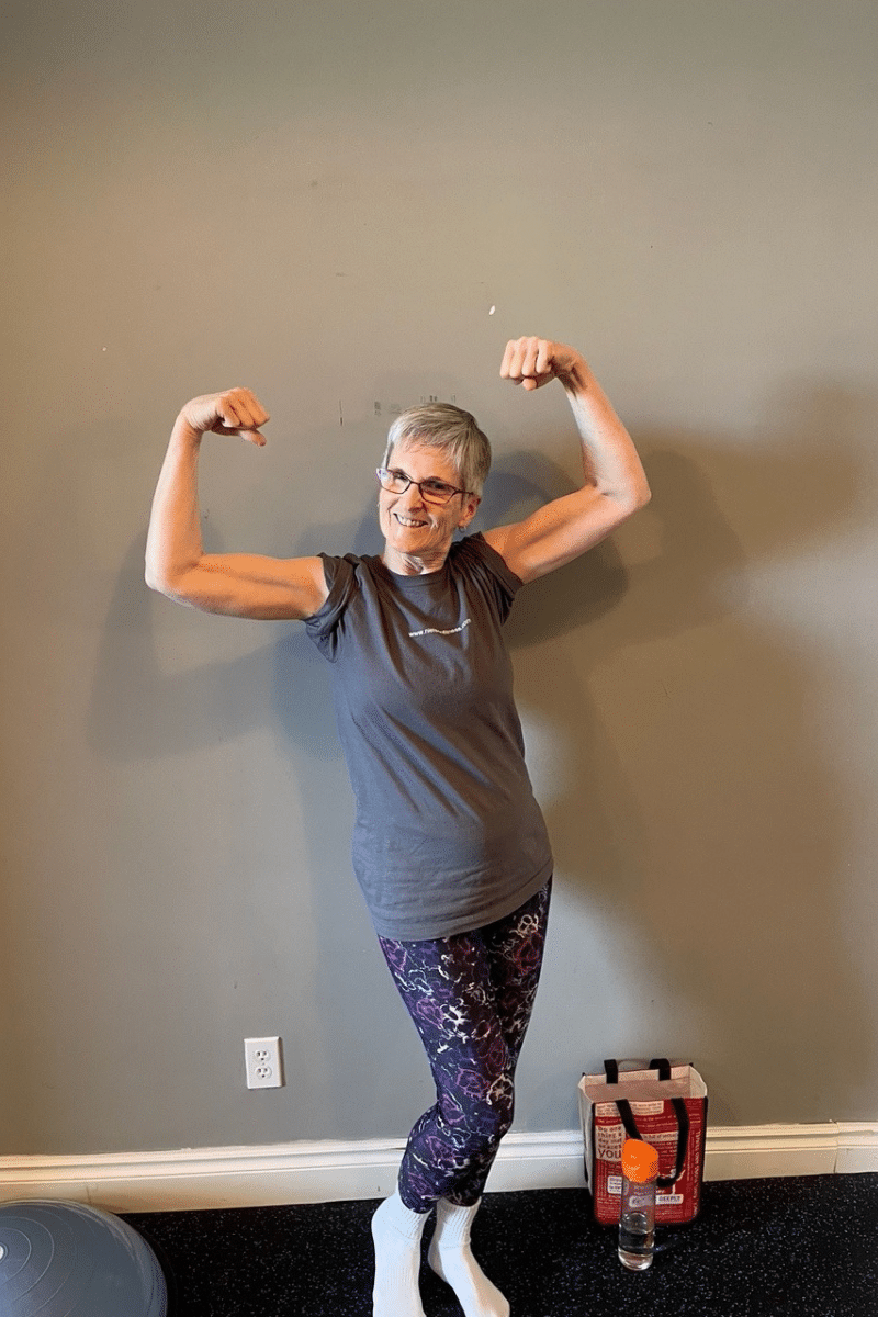 a clients flexes her muscles to demonstrate the benefits of personal training for seniors