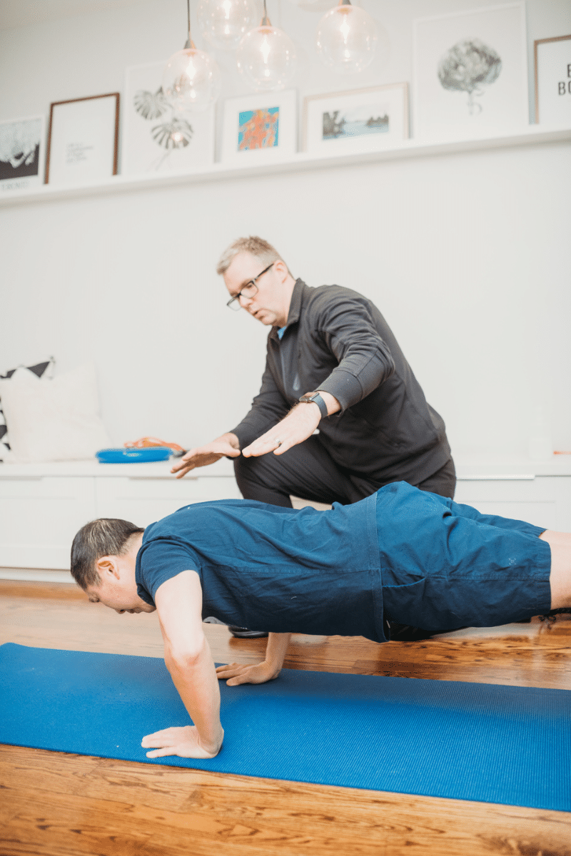 a personal trainer leads a client through a bodyweight training session