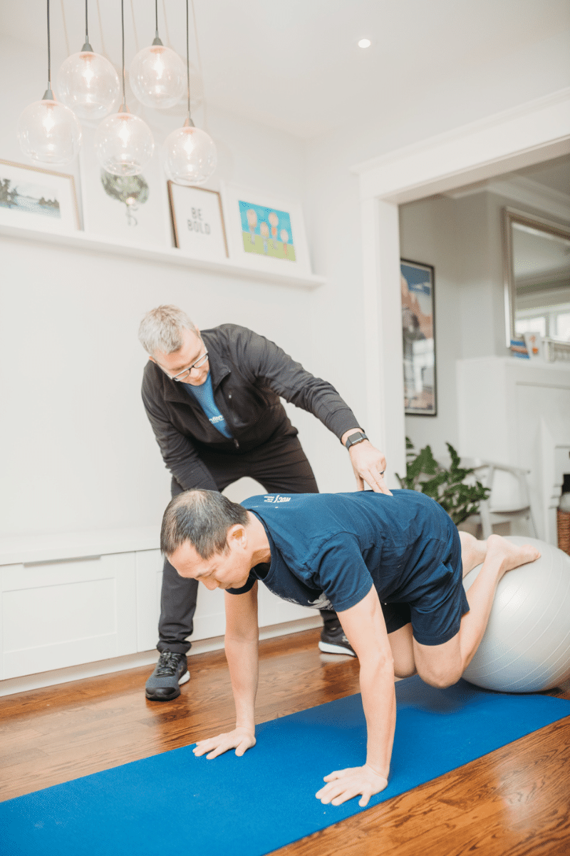 a personal trainer helps a client with their form