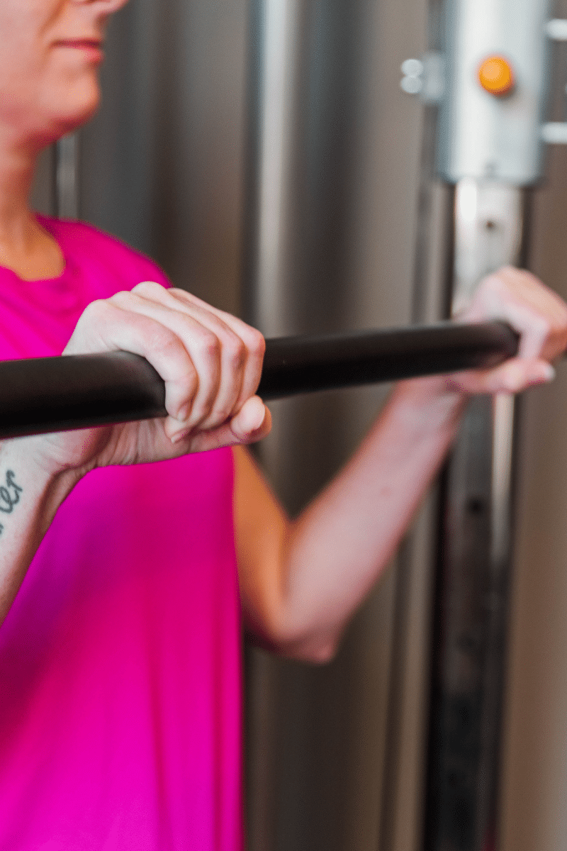 a woman holding a bar prepares to begin a fitness program