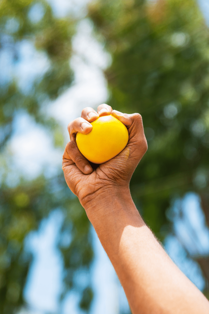 a client starting personal training over 50 works on grip strength with a rubber ball